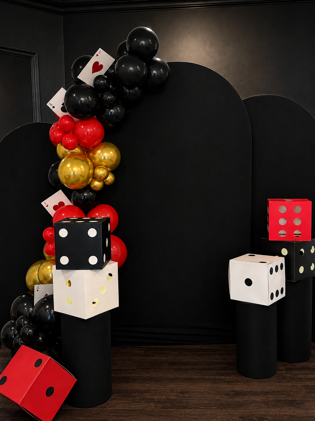 Black red and gold casino themed balloon garland, playing card accents, dice props, and black backdrop in Clermont Florida